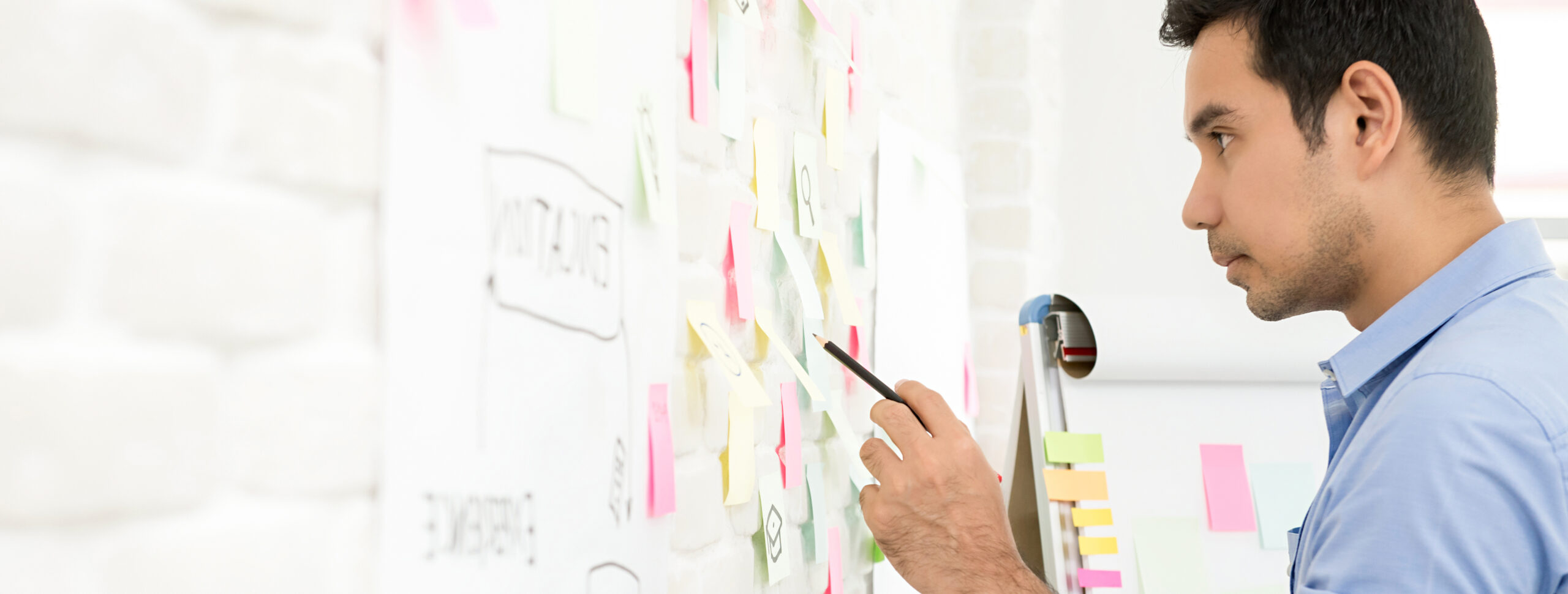 Businessman looking for information from sticky notes on the wall